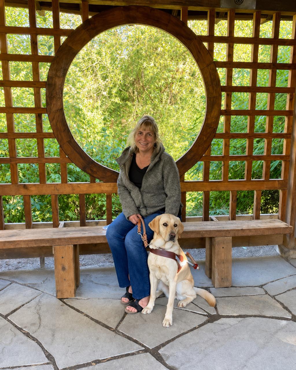 Lisa Bentz sitting with her guide dog, Tera, outdoors