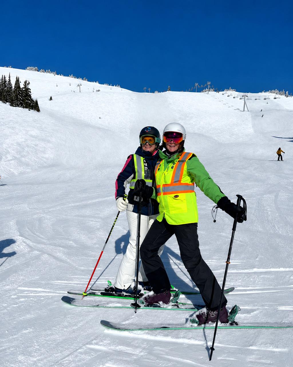 Lisa skiing with a companion on a snowy mountain